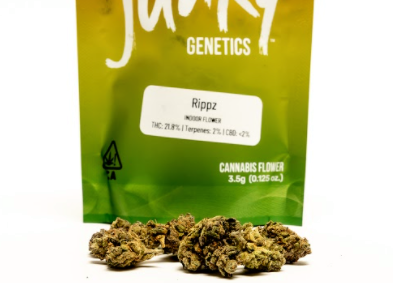 The Rippz Strain from Seed Junky Genetics pictured packaged in an ounce size of Red, Yellow, and Green sealable baggie.