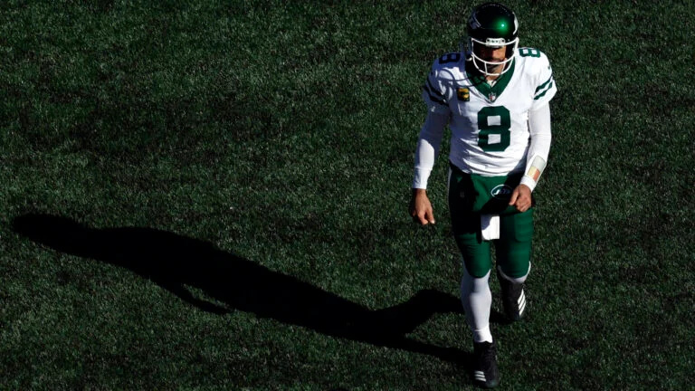 Aaron Rodgers of the New York Jets, walking off the field after the Jets were defeated by the New England Patriots earlier in the 2024 NFL season.